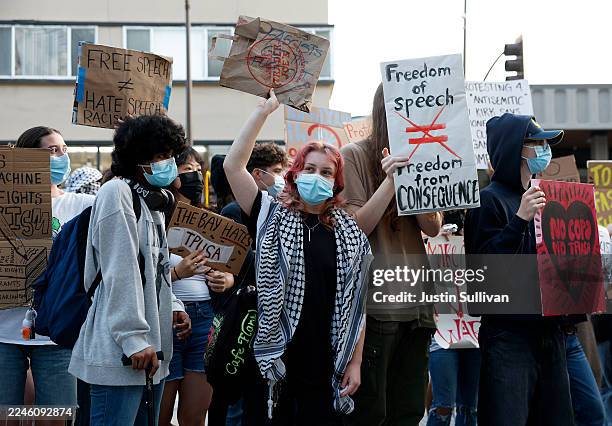 Protesters hold signs as they demonstrate outside of a Turning Point USA event at the University of California, Berkeley on November 10, 2025 in...