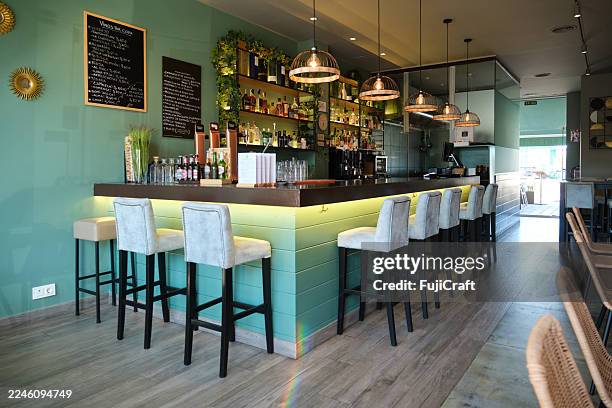 modern bar counter with stools and shelves full of bottles - pub wall stock pictures, royalty-free photos & images