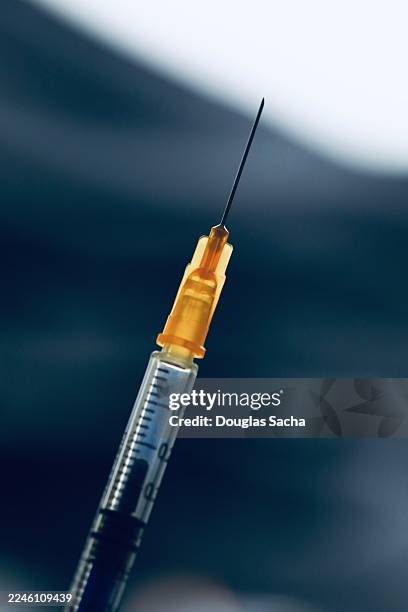 syringe with needle - achatar la curva de epidemia fotografías e imágenes de stock