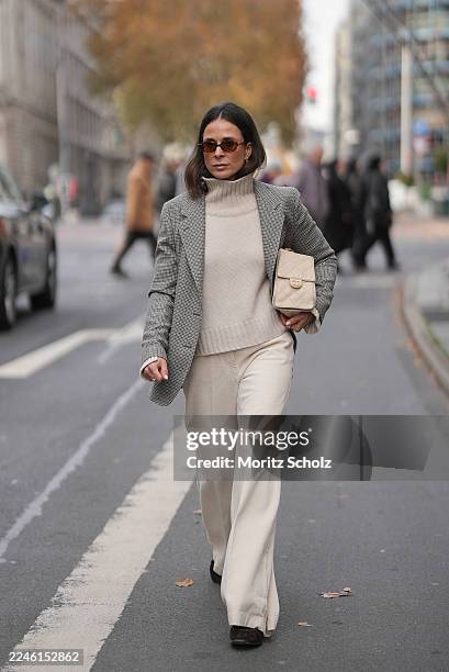 Duesseldorf, GERMANY Patricia Wirschke is seen wearing a beige turtleneck cashmere sweater with a wide collar by Soft Goat; high-waisted wide-leg...