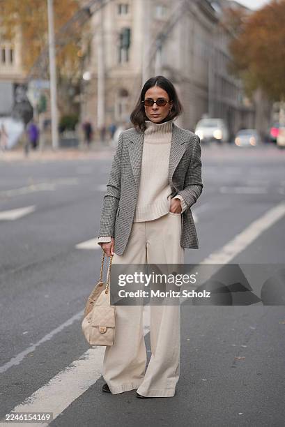 Duesseldorf, GERMANY Patricia Wirschke is seen wearing a beige turtleneck cashmere sweater with a wide collar by Soft Goat; high-waisted wide-leg...