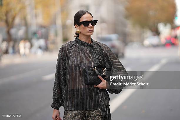 Duesseldorf, GERMANY Patricia Wirschke is seen wearing a shimmering metallic striped blouse in shades of charcoal, bronze, and silver with a see...