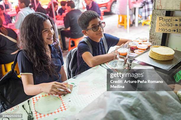 children buying tortillas on their way home after school - die neue normalität stock-fotos und bilder