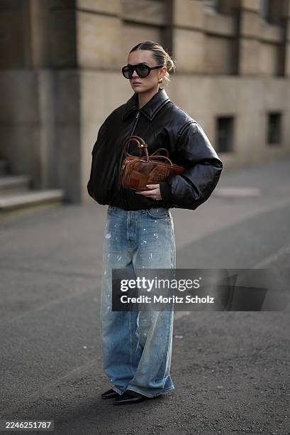 Duesseldorf, GERMANY Romina Meier is seen wearing a dark brown bomber jacket with a coated leather finish, zip closure and classic collar from Acne...