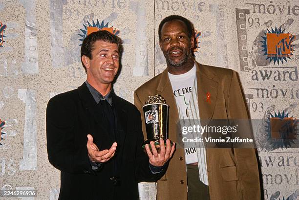 American actor and film director Mel Gibson, wearing a black blazer over a black shirt with a grey collar, and American actor Danny Glover, who wears...
