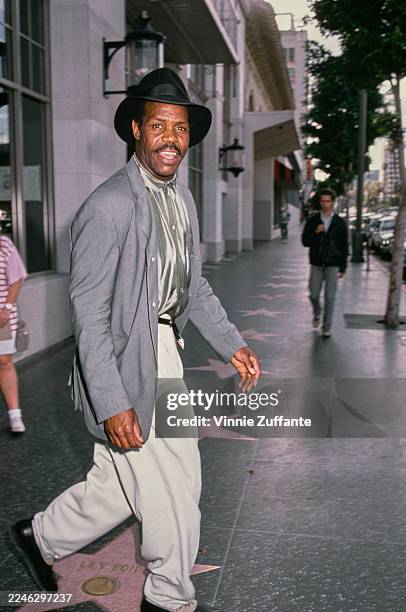 American actor Danny Glover, wearing a grey fine-check blazer with white trousers, attends the International Documentary Association Film Awards at...