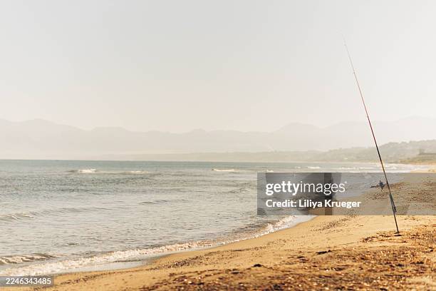 golden sandy beach with soft waves at sunset - cana de pesca imagens e fotografias de stock