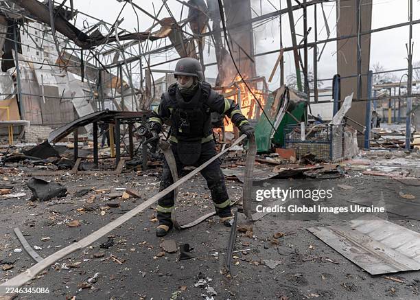 Ukrainian State Emergency Service workers localize a fire at a hangar of a civilian enterprise destroyed by a Russian drone strike on November 12,...