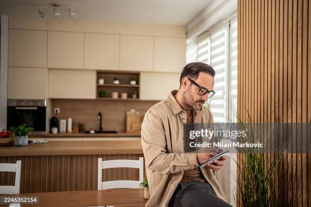 mann, der im notizblock schreibt und tägliche aufgaben plant - die neue normalität stock-fotos und bilder