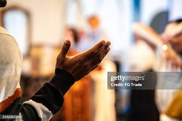 gros plan d’un homme priant dans une église - christianisme photos et images de collection