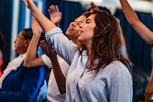 Mid adult woman worshiping on a church Mid adult woman worshiping on a church