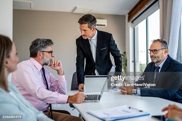 profesionales de negocios discutiendo estrategia durante una reunión corporativa - capataz fotografías e imágenes de stock