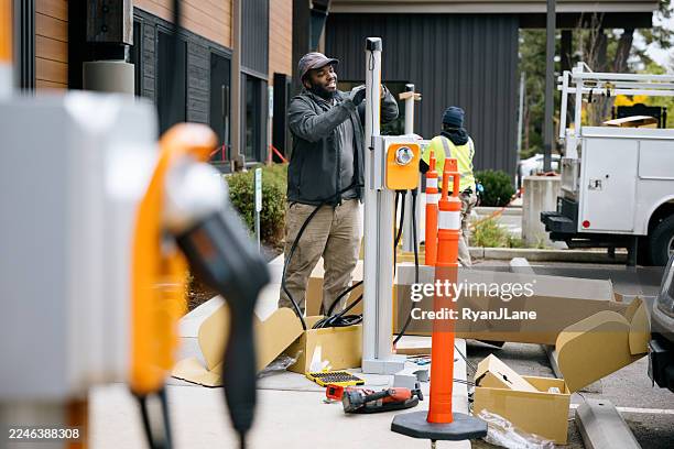 electric vehicle charging station installation - battery charger stock pictures, royalty-free photos & images