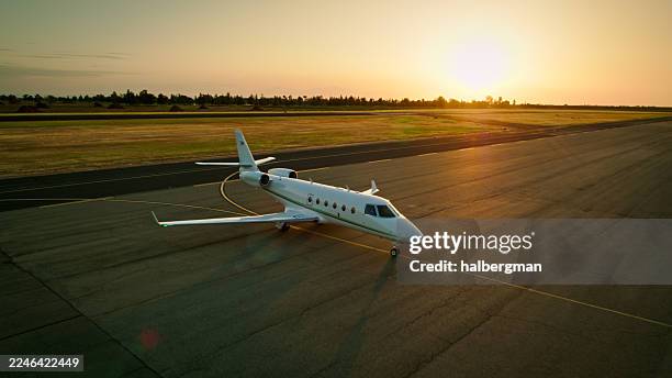 showcase style photo of private jet parked on private airport tarmac at sunset - private aeroplane stock pictures, royalty-free photos & images