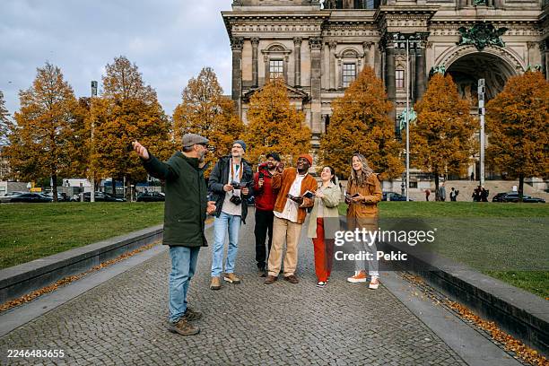 group of people exploring berlin with tour guide - berlin tourist stock pictures, royalty-free photos & images