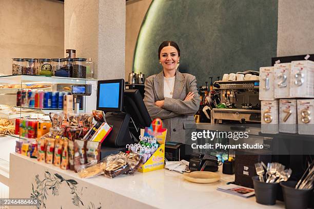 propietario de una cafetería simpático de pie detrás del mostrador en una cafetería moderna - achatar la curva de epidemia fotografías e imágenes de stock