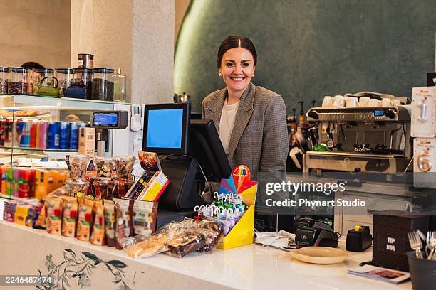 propietario de una cafetería simpático de pie detrás del mostrador en una cafetería moderna - achatar la curva de epidemia fotografías e imágenes de stock