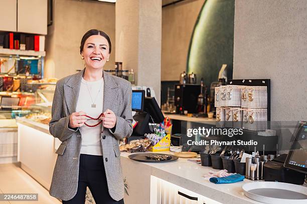 femme souriante debout dans un café moderne - aplatir la courbe photos et images de collection