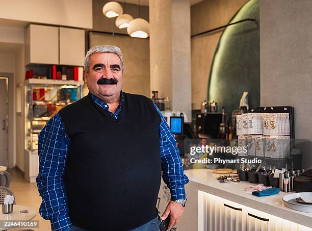 propietario de un café seguro de sí mismo de pie dentro de una cafetería moderna - achatar la curva de epidemia fotografías e imágenes de stock