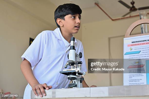 curious middle schooler with microscope in science lab - middle schooler stock pictures, royalty-free photos & images