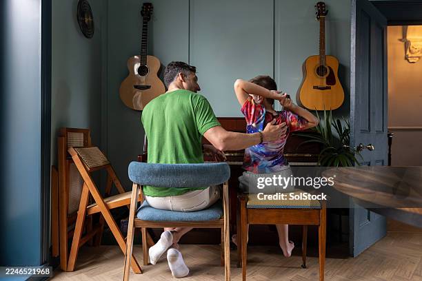 happy father and son playing piano side by side - encouragement stock pictures, royalty-free photos & images