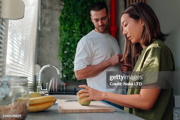 paar bereitet gesundes frühstück mit frischem obst in der küche zu - die neue normalität stock-fotos und bilder