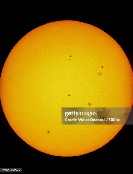 close-up of the suns surface with visible sunspots against a black background - sonnenflecken stock-fotos und bilder