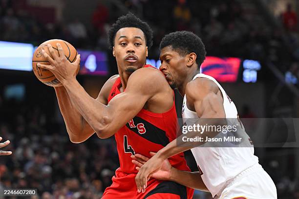 Forward Scottie Barnes of the Toronto Raptors drives to the basket around forward De'Andre Hunter of the Cleveland Cavaliers during the fourth...