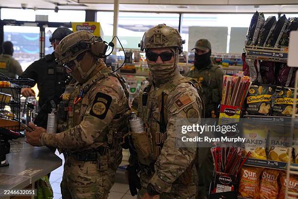 Border Patrol agents walk through a gas station while searching for undocumented immigrants on November 17, 2025 in Charlotte, North Carolina....