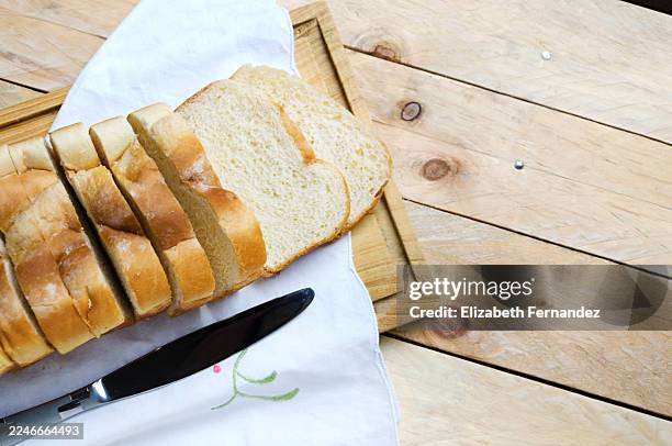 sliced white bread on wooden board with knife - white bread stock pictures, royalty-free photos & images