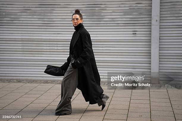 Sandra Ebert is seen wearing an oversized Bobby Coat Black with boxy fit, wide shoulders with pads and a sharp lapel collar from black palms; a...