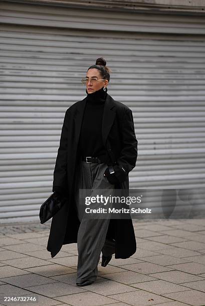 Sandra Ebert is seen wearing an oversized Bobby Coat Black with boxy fit, wide shoulders with pads and a sharp lapel collar from black palms; a...