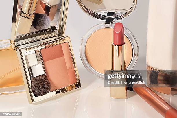 luxury makeup products — face powder, blush, lipstick and brushes in golden cases on light background. beauty and fashion cosmetic concept, close-up. - industrie de la mode photos et images de collection