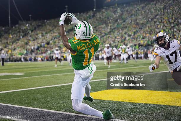 Jeremiah McClellan of the Oregon Ducks scores a touchdown while defended by John Nestor of the Minnesota Golden Gophers during the second half...