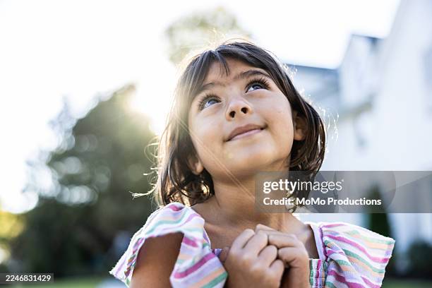 portrait of young girl in front of suburban home - innocenza foto e immagini stock