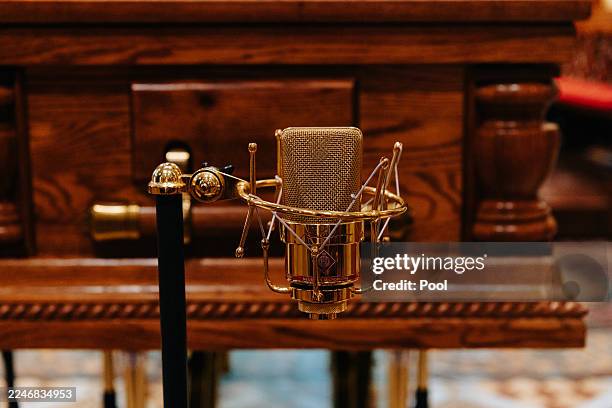 Golden microphone is placed in front of the coffin during a state funeral for John Laws at St. Andrew's Cathedral on November 19, 2025 in Sydney,...