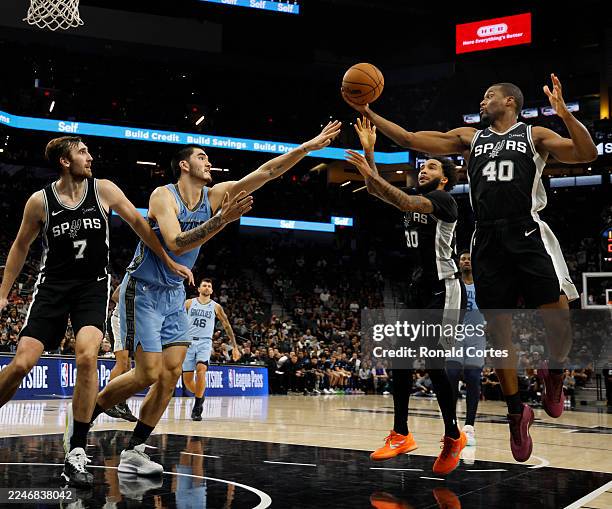 Harrison Barnes of the San Antonio Spurs grabs a rebound against Zach Edey of the Memphis Grizzlies in the second half at Frost Bank Center on...