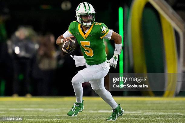 Dante Moore of the Oregon Ducks scrambles out of the pocket to throw a pass during the second half against the Minnesota Golden Gophers at Autzen...