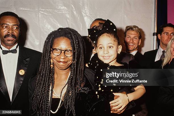 American actress and comedian Whoopi Goldberg, wearing a black outfit with a pearl necklace, and American child actress Raven-Symoné attend the 23rd...