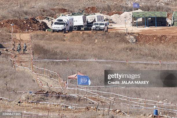 Photograph taken from the Israeli side of the border with southern Lebanon shows members of the United Nations Interim Force in Lebanon clearing...