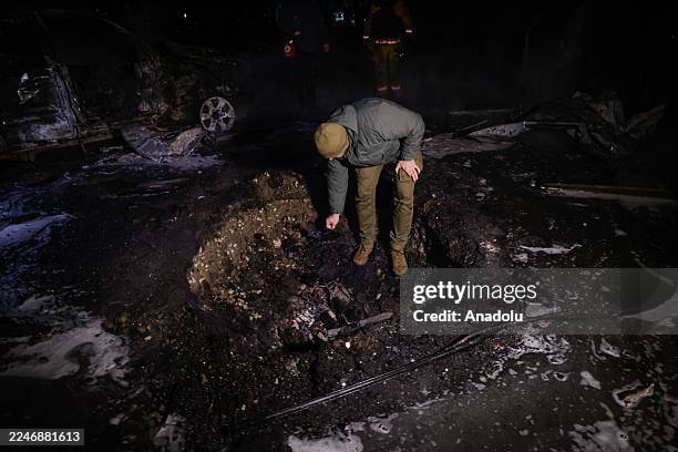 An explosives technician inspects a hole left by a Shahed bomb near a residential building in Kharkiv, Ukraine on November 19, 2025. As a result of...