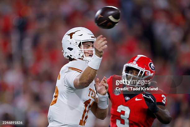 Arch Manning of the Texas Longhorns passes the ball under pressure from CJ Allen of the Georgia Bulldogs during the first quarter of the game at...