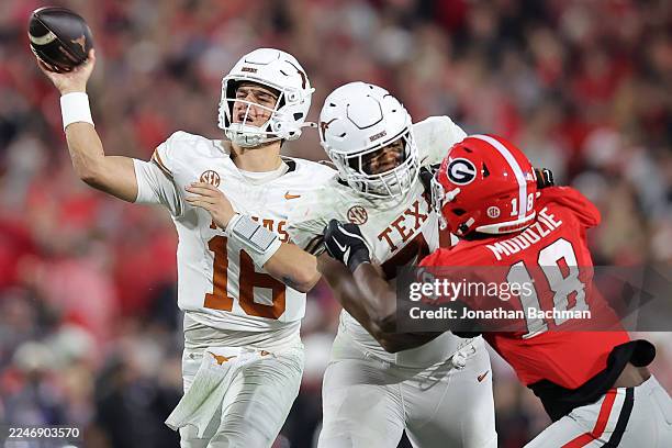 Arch Manning of the Texas Longhorns throws the ball as Elo Modozie of the Georgia Bulldogs defends during the second half at Sanford Stadium on...