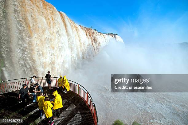 turistas reunidos en un mirador sobre las cataratas iguaçu, brasil - cataratas del iguazú fotografías e imágenes de stock