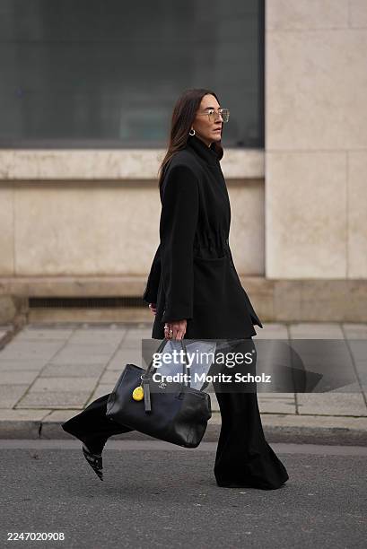Sandra Ebert is seen wearing a structured black Blazy blazer with elastic waist band, wide shoulders with shoulder pads and lapel collar from black...