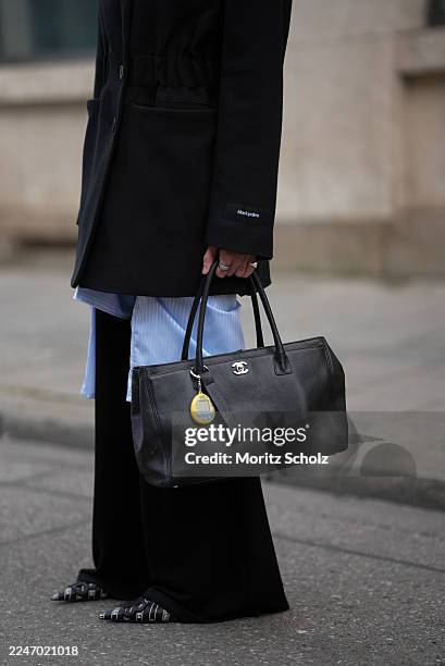 Sandra Ebert is seen wearing a structured black Blazy blazer with elastic waist band, wide shoulders with shoulder pads and lapel collar from black...