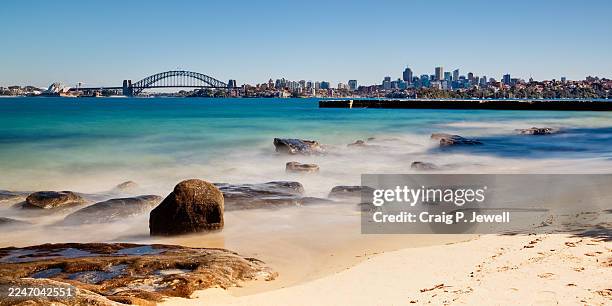 sydney harbour and sydney skyline from bradley's head on a warm winter morning with beach in foreground - sydney skyline stock pictures, royalty-free photos & images