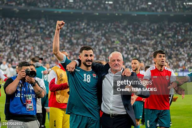 Aymen Hussein raises his fist as he celebrates alongside Iraq head coach Graham Arnold in Basra, Iraq, on November 18, 2025. The match is part of the...