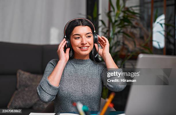 smiling woman with headphones working from home at laptop for virtual meeting - female likeness stock pictures, royalty-free photos & images