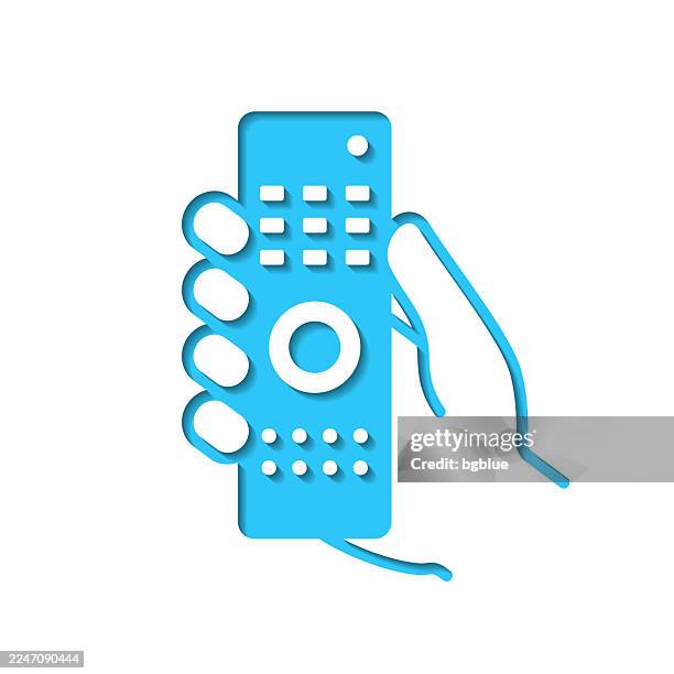 hand holding remote control. icon cut out on white paper with blue background - remote controlled stock illustrations